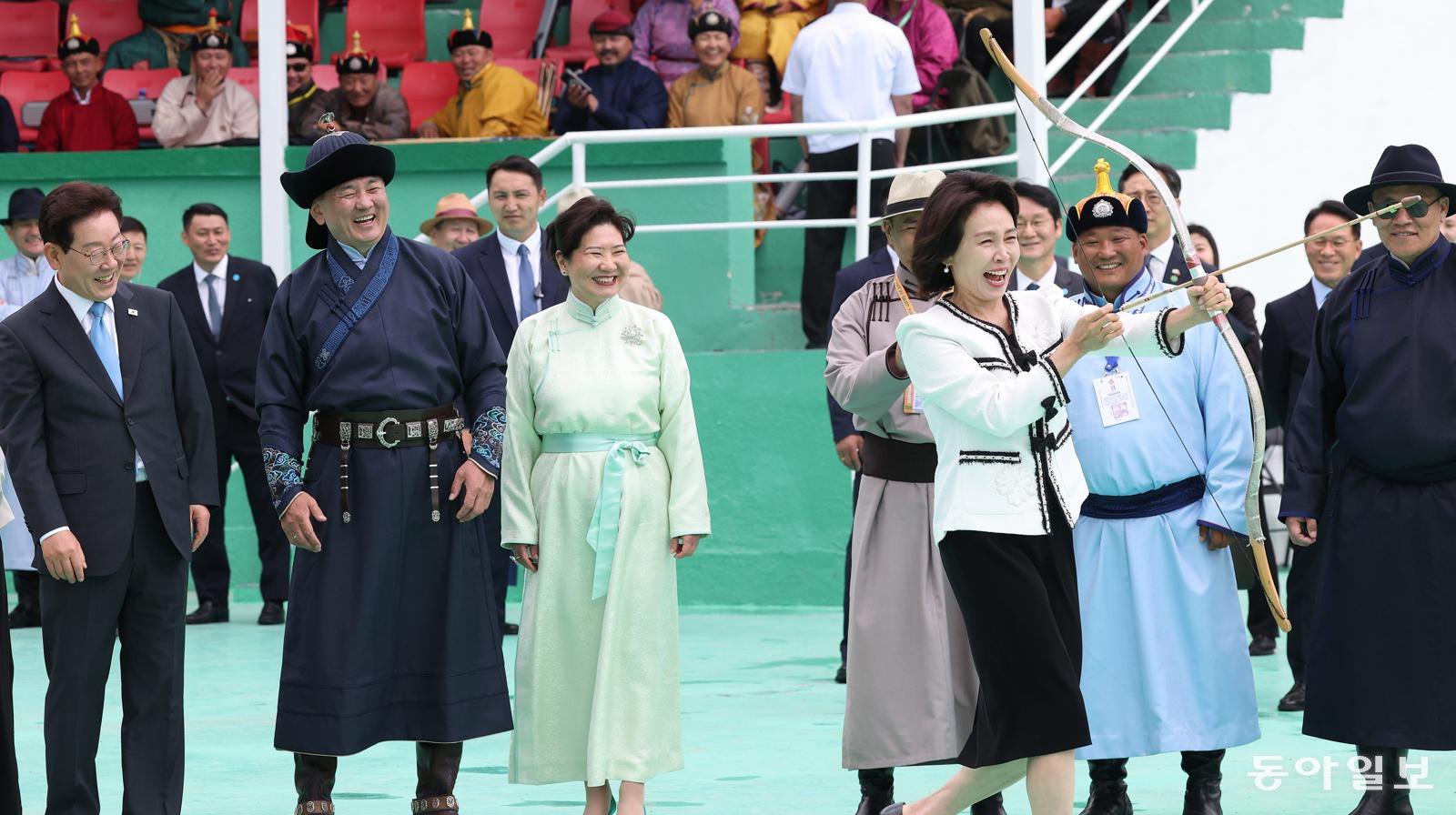 김혜경 여사가 11일(현지시간) 몽골 울란바타르 전통활쏘기 경기장에서 활을 쏘기 위해 이동하고 있다. 뒤쪽으로 이재명 대통령, 몽골 오흐나 후렐수흐 대통령, 룹산도르진 볼로르체체그 여사가 웃음을 짓고 있다. 울란바타르=김재명 기자 base@donga.com