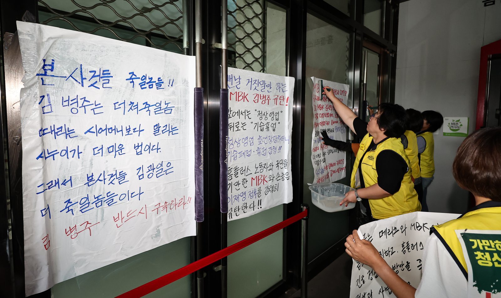 마트산업노조 홈플러스지부 조합원들이 14일 서울 강서구 홈플러스 본사 입구에서 MBK의 일방적 면담 취소 규탄 및 노조 입장발표 기자회견을 마치고 본사에 항의하는 내용을 담은 대자보를 붙이고 있다. 2026.7.14 뉴스1