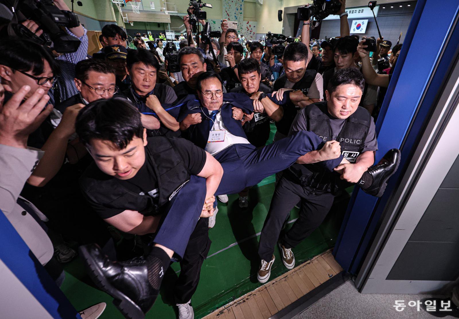 15일 오후 충북 충주시 한국교통대 체육관에서 충주시장선거 당선무효소청 투표지 검증이 실시되고 있다. 소청인인 맹정섭 전 더불어민주당 후보가 CCTV 공개를 촉구하다가 조미연 충북도선관위 위원장의 강제 퇴거 명령에 검증장 밖으로 쫓겨나고 있다. 충주=이한결 기자 always@donga.com