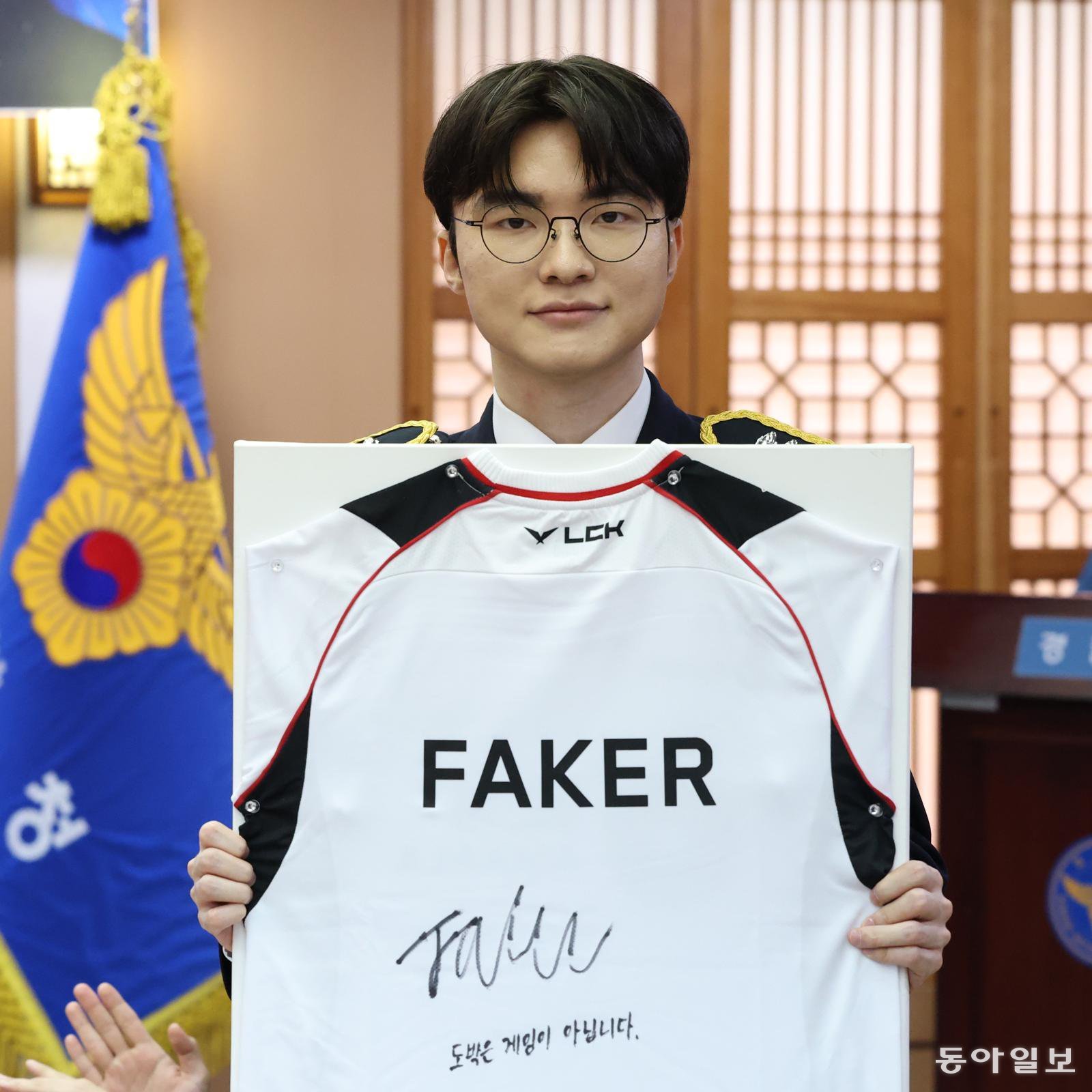 프로게이머 ‘페이커’ 이상혁이 22일 서울 서대문구 경찰청에서 명예경찰 및 사이버도박 예방 홍보대사로 위촉된 가운데 도박 중독을 극복한 청소년들에게 전달할 유니폼에 사인을 한 뒤 들어 보이고 있다.

김재명 기자 base@donga.com
