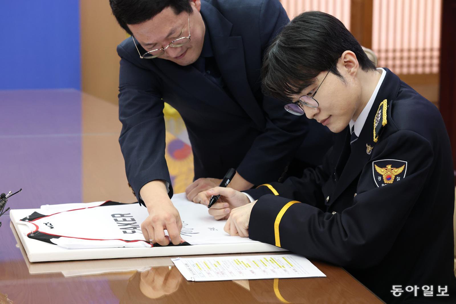 프로게이머 ‘페이커’ 이상혁이 22일 서울 서대문구 경찰청에서 명예경찰 및 사이버도박 예방 홍보대사로 위촉된 뒤 유니폼에 사인을 하고있다. 김재명 기자 base@donga.com