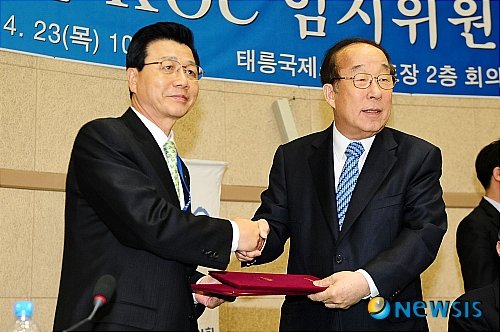 평창23일 오전 태릉선수촌내 국제스케이팅장에서 대한올림픽위원회(KOC) 임시위원총회가 열린 가운데 박용성 위원장이 평창의 동계올림픽 유치 국내후보도시 확정 후 김진선 강원도지사와 협정서를 나누며 악수하고 있다. 이번 총회에서는 2018년 동계올림픽 유치 국내후보도시를 신청한 평창에 대해 무기명 비밀투표를 실시한 결과 총 43표 중 찬성 30표, 반대 13표로 안건을 통과시켰다. 【서울=뉴시스】