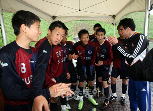 ‘춥지만 조금만 더 힘내자.’ 윤태석 기자(맨 오른쪽)가 하프타임 때 수성중 선수들을 모아놓고 박수를 치며 파이팅을 강조하고 있다. 이날 장대비가 쏟아져 선수들은 흠뻑 젖은 채 70분 경기를 소화해야 했다. 수원·용인｜박화용 기자 inphoto@donga.com
