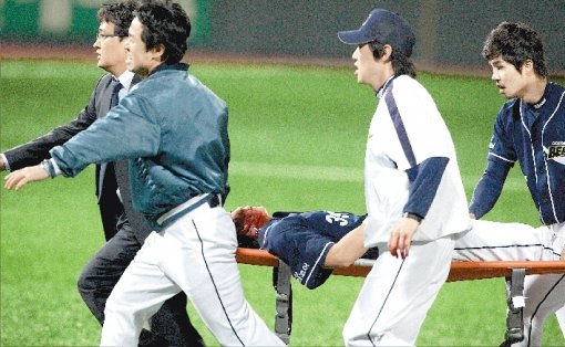 두산 중견수 이종욱이 2일 광주 KIA전 8회말 김종국의 타구를 잡으려다 2루수 김재호와 충돌해 쓰러진 후 목부위에 피를 흘리며 기절해 들것에 실려 급히 구급차로 옮겨지고 있다.