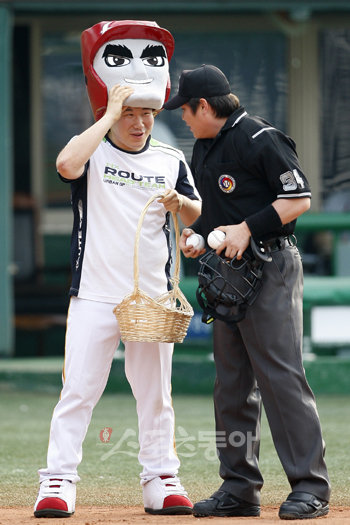“너 누구야?” 일일 턱돌이 체험에 나선 전영희 기자(왼쪽)가 21일 목동 한화-히어로즈전 더블헤더 2경기 시작을 앞두고 우효동 심판에게 공을 전해주면서 턱돌이 마스크를 살짝 들어올리며 인사하고 있다. 목동 ｜ 임진환 기자 photolim@donga.com