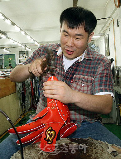 ‘못질하는 게 아닙니다. 글러브 만드는 데도 망치가 필요하죠.’ 전영희 기자가 직접 글러브를 만들고 있다. 외피조각을 재봉으로 이어 붙이면 재봉 부분이 울퉁불퉁해기 때문에 망치로 쳐야 평평해진다. 글러브 구석구석 한치의 오차도 없이 손길이 닿아야 한다.부산 | 박화용 기자 keystone@donga.com