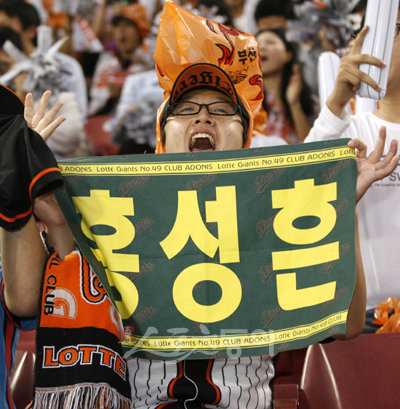 “홍성흔이 최고야” 한 여성 관중이 롯데 팬의 트레이드마크 주황색 비닐봉지를 머리에 쓴 채 홍성흔의 이름이 적힌 수건을 들고 열정적으로 응원하고 있다. 잠실｜임진환 기자 photolim@donga.com