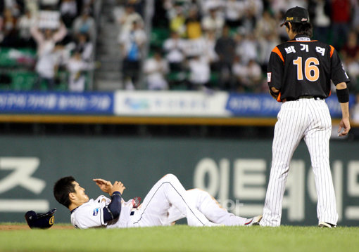 30일 저녁 서울 잠실야구장에서 열린 2009프로야구 두산과 롯데의 준플레이오프 2차전에서 6회말 1사 1루 두산 9번 타자 용덕한 삼진때 2루로 파고들며 도루에 성공한 1루 주자 임재철이 새끼 손가락 탈골로 그라운드에 누워 고통스러워하고 있다. 잠실ㅣ박화용 기자 inphoto@donga.com