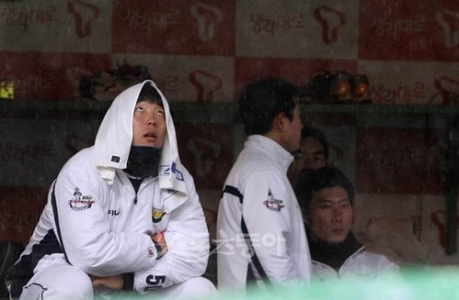 야속한 하늘, 애타는 현수 2회 솔로홈런을 기록한 두산 김현수가 갑작스러운 폭우로 경기가 중단되자 수건을 머리에 쓰고 하늘을 멍하니 바라보고 있다. 문학 ｜ 김종원 기자 won@donga.com