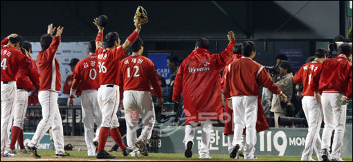 24일 서울 잠실야구장에서 열린 2009프로야구 한국시리즈 7차전 KIA타이거즈 대 SK와이번스의 경기. 5:5 동점 상황 9회말 1사 상황에서 KIA 나지완이 SK 마무리 투수 채병용을 상대로 결승 솔로 홈런을 날리며 경기 종료, KIA가 V10 달성에 성공했다. 준우승에 머문 SK 선수들이 팬들에게 인사하며 퇴장하고 있다. 잠실 | 양회성 기자 yohan@donga.com