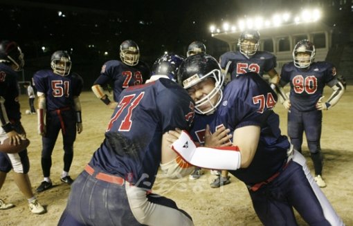 전영희 기자가 홍익대 미식축구부원들이 지켜보는 가운데 1대1 몸싸움 훈련을 하며 힘겨운 표정을 짓고 있다. 미식축구에서는 상대방과의 몸싸움에서 지지 않는 것이 기본이다. 내가 뚫리면 팀 전체가 무너지기 때문에 미식축구의 기본정신 가운데 하나는 희생이다.임진환 기자 photolim@donga.com
