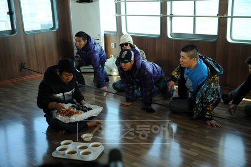 충무김밥의 유혹. 먹으면 반드시 고등어 잡이 배를 타야한다는 제작진의 말에도 ‘1박2일’ 멤버들의 시선은 이미 충무김밥을 향해 있다. [사진제공=KBS]