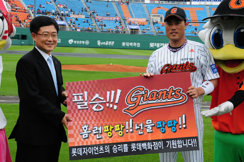 12일 부산지역 롯데백화점 영남지역본부장 강희태 상무(왼쪽)가 롯데 주장 조성환에게 ‘자이언츠 후원 이벤트’ 포상금을 전달하고 있다. [사진제공=롯데백화점]