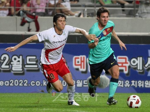 손까지 동원해봤지만…   FC바르셀로나 리오넬 메시(오른쪽)가 특유의 감각적인 드리블로 K리그 올스타 김창수를  따돌리며 골문으로 쇄도하고 있다. 상암 ｜ 김종원 기자 won@donga.com