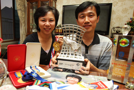 여민지 어머니 임수영 씨(왼쪽)와 아버지 여창국 씨가 17일 김해 자택에서 가진 스포츠동아와 인터뷰에서 여민지가 딴 메달 등을 들어 보이며 자랑스러워하고 있다. 김해 ｜ 국경원 기자 onecut@donga.com