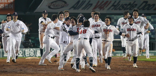 8-8로 맞선 연장 11회말 무사 2.3루에서 두산 손시헌(가운데)의 끝내기 안타가 터지자 선수들이 몰려나와 얼싸안으며 기뻐하고 있다.