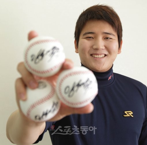 두산 임태훈이 ‘트위터 인터뷰’를 위해 질문을 보내준 3명의 팬을 직접 선정해 사인볼을 전달한다. 사인볼을 들고 환하게 웃고 있는 모습.잠실 ｜ 임진환 기자(트위터 @binyfafa) photolim@donga.com