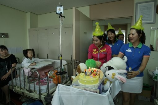 김하늘(왼쪽)을 비롯한 우리투자증권 프로골프단 소속 선수들이 서울 여의도 성모병원 어린이 병실을 찾아 환우를 위한 이벤트를 열고 있다.