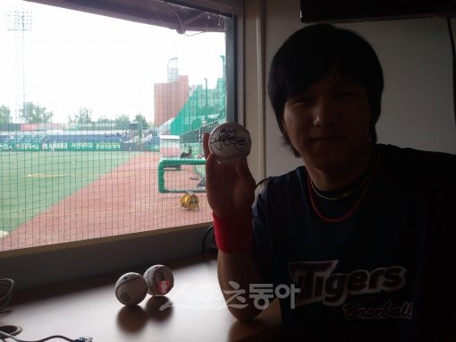 김선빈이 직접 뽑은 팬 3명에게 선물할 사인볼을 들고 기분 좋게 웃고 있다.