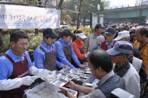 최경주(왼쪽)가 13일 오전 서울 사당역 인근에서 노숙자들을 위한 무료급식 봉사활동에 참여한 뒤 오후에는 골프꿈나무들을 위한 자선기금 마련 이벤트를 펼치는 등 행복한 하루를 보냈다. 사진제공｜최경주재단