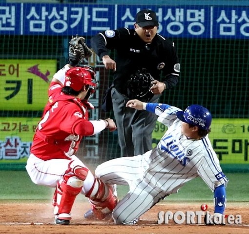 홈에서 충돌한 포수와 주자 그리고 집중하는 심판. 1차전 6회말 1사 만루에서 삼성 최형우(오른쪽)가 진갑용의 뜬공을 SK 2루수 정근우가 놓치는 사이 홈으로 뛰어들다 정상호에 막혀 아웃되고 말았다. 사진제공|스포츠코리아