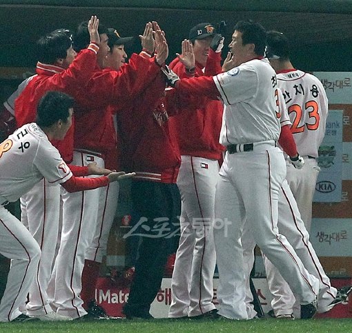 프로야구 30년 역사상 처음으로 한국시리즈에서 터진 40대의 홈런. 우리 나이로 마흔 하나, SK 최고참 최동수가 28일 문학 3차전 1-0으로 앞선 5회말 사실상 승리를 굳히는 솔로홈런을 때린 뒤 덕아웃에서 동료들과 함께 기뻐하고 있다. 문학|임진환 기자 photolim@donga.com 트위터@binyfafa