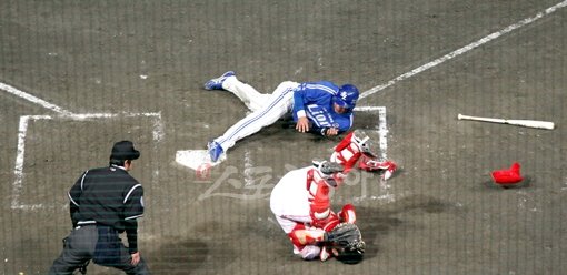 여기가 승부처!삼성의 4회초 공격 2사 2루. 진갑용의 좌전안타를 틈타 홈을 파고 들던 2루주자 강봉규(가운데)는 SK 포수 정상호(아래쪽)의 블로킹에 막혔다. 주자의 발은 홈플레이트에 걸쳐있고, 포수는 중심을 잃고 쓰러져 있지만 결과는 아웃. SK 좌익수 박재상의 멋진 홈 송구가 빛을 발한 순간이었다. 문학 | 국경원 기자 onecut@donga.com 트위터 @k1isonecut