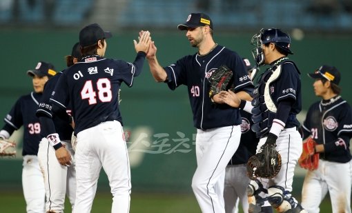 두산 니퍼트(가운데)가 13일 사직 롯데전에서 9이닝 4안타 1실점으로 역투하며 올 시즌 8개 구단 투수 중 첫 완투승을 
기록했다. 끝까지 직접 경기를 마무리한 니퍼트가 마운드에서 동료들과 하이파이브로 기쁨을 나누고 있다. 사직｜김민성 기자 
marineboy@donga.com 트위터 @bluemar007