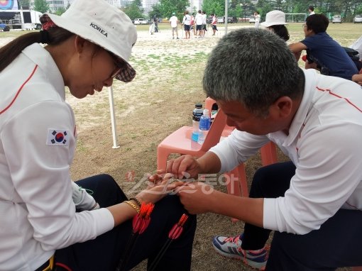 4일 강원도 원주 제1군수지원사령부 대운동장에서 열린 2012런던올림픽 양궁대표팀의 최종 시뮬레이션 훈련 경기. 여자대표팀 박채순
코치(오른쪽·광주광역시청 감독)가 샌드페이퍼를 이용해 최현주(창원시청)의 오른손 검지 굳은살을 다듬어주고 있다. 샌드페이퍼는
굳은살 관리가 중요한 양궁선수들의 필수품이다. 원주|전영희 기자