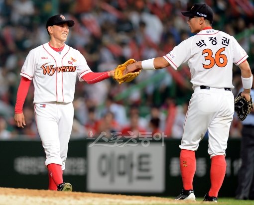 SK 1루수 박정권(오른쪽)이 13일 문학 두산전 7회초 무사 1루서 김동주의 플라이 타구를 잡은 뒤 선발 박정배에게 공을 건네며 격려하고 있다. 문학|김민성 기자 marineboy@donga.com 트위터 @bluemarine007