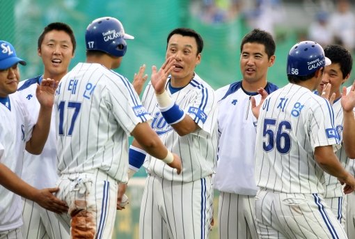 ‘잘 했어, 태인아!’ 삼성 이승엽(오른쪽)이 25일 대구 SK전 1회 2사 만루서 조동찬의 2루타 때 1루서 홈까지 파고들어 팀의 5점째를 올린 채태인(17번)을 덕아웃에서 반갑게 맞이하고 있다. 사진제공|스포츠코리아