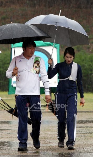 국군체육부대 오진혁과 안양서중 기보배가 양궁경기장에서 처음 만난 지 벌써 10년여의 시간이 흘렀다. 이제 이들은 서로를 격려하고 채찍질하며 함께 미래를 꿈꾸는 ‘신궁 커플’이 됐다. 비 오는 훈련장에서 우산을 쓰고 나란히 걷는 오진혁(왼쪽)과 기보배. 스포츠동아DB