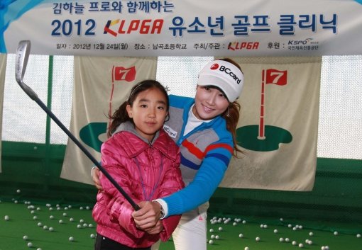 김하늘(오른쪽)이 24일 경기도 용인 남곡초등학교에서 열린 유소년 골프 클리닉에서 초등학생의 스윙 자세를 교정해주고 있다. 사진제공|KLPGA