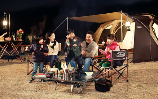 은은한 램프 불빛 아래에서 고기를 구워먹으며 도란도란 대화를 나누는 캠핑이야말로 가족이 누릴 수 있는 큰 행복 중 하나다. 테이블, 램프, 캠프파이어 세트 등 아기자기한 소품을 활용하면 더욱 재미있는 캠핑을 즐길 수 있다. 사진제공｜콜맨
