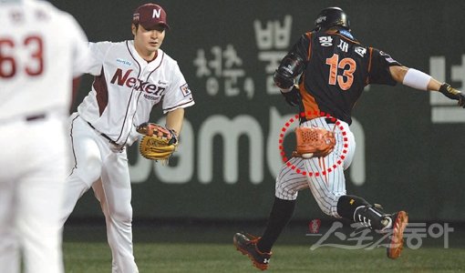 넥센 투수 한현희(왼쪽)가 9일 목동 롯데전 8회초 선두타자로 나온 황재균(오른쪽)의 땅볼 타구를 잡았지만 공이 박혀 빼낼 수 없자 글러브째로 1루수 박병호에게 던지고 있다. 어떻게든 아웃카운트를 잡으려 했던 한현희의 투혼에도 불구하고 황재균은 1루에서 살았고, 1-2로 추격하는 득점까지 했다. 목동|김민성 기자 marineboy@donga.com 트위터 @bluemarine007