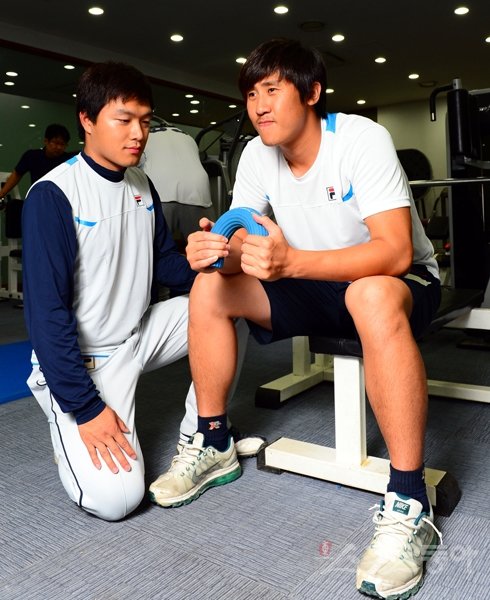 두산 이용찬(오른쪽)은 2월 오른쪽 팔꿈치 뼛조각 제거수술을 받은 뒤 재활에 몰두해왔다. 최근 불펜피칭을 소화하며 복귀가 얼마 남지 않았음을 알린 이용찬이 합류하면 두산 마운드에 큰 힘이 될 전망이다. 이용찬이 트레이너의 도움 속에 재활훈련을 하고 있다. 잠실｜박화용 기자 inphoto@donga.com 트위터 @seven7sola