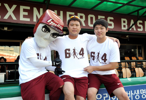 넥센 송신영이 25일 목동 KIA전에 앞서 우완 정통파 투수 최다 출장 기록(614경기)을 기념하기 위해 팬들이 선물한 티셔츠를 입고 포즈를 취했다. 왼쪽은 넥센 마스코트인 턱돌이, 오른쪽은 후배 투수 한현희다. 사진제공|넥센 히어로즈