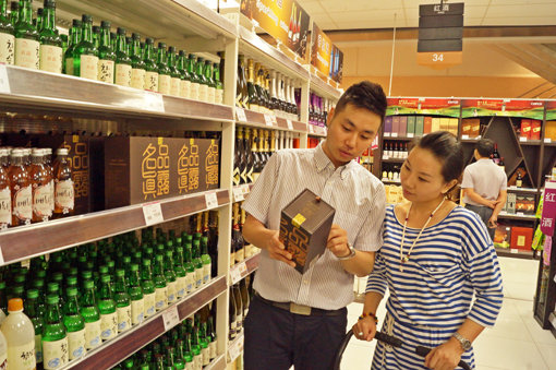 하이트진로가 급성장하고 있는 중국시장 공략에 적극 나섰다. 하이트진로는 최근 중국에 2017년까지 2500만 달러를 수출하겠다는 청사진을 확정했다. 한 중국 소비자가 베이징 대형마트에서 신제품 ‘명품진로’를 고르고 있다. 베이징(중국)｜하이트진로