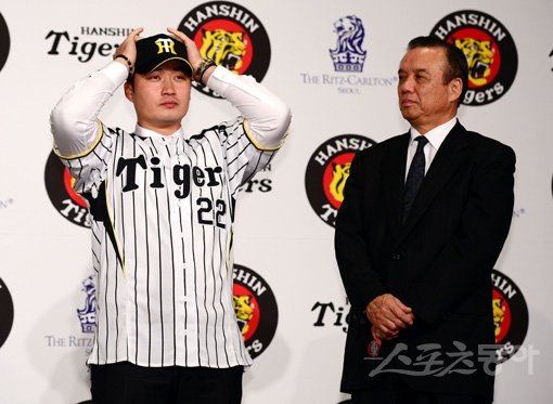 이제 ‘한신 수호신’ 오승환이다. 4일 서울 리츠칼튼 호텔에서 열린 한국 입단식에서 오승환(왼쪽)이 22번이 새겨진 한신 유니폼을 입고 모자를 쓰고 있다. 곁에선 나카무라 가쓰히로 한신 단장이 믿음직스러운 표정으로 바라보고 있다. 김민성 기자 marineboy@donga.com 트위터 @bluemarine007