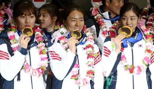 ‘달콤한 메달, 행복한 귀국, 반가운 대한민국.’ 25일 인천국제공항을 통해 귀국한 2014소치동계올림픽 한국 선수단의 박승희, 이상화, 김연아(왼쪽부터)가 초콜릿으로 제작된 특별 메달을 들고 인사하고 있다. 인천국제공항｜김민성 기자 marineboy@donga.com 트위터 @bluemarine007