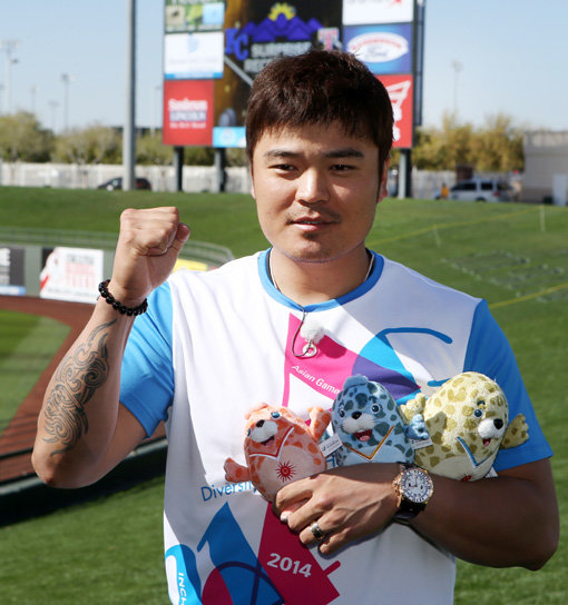 인천아시안게임 홍보대사로 위촉된 메이저리거 추신수(텍사스)가 기념 티셔츠와 마스코트를 들고 대회의 성공적 개최를 기원하고 있다. 사진제공｜인천아시아경기대회조직위원회