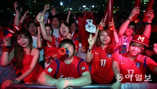 한국과 러시아의 경기를 하루 앞둔 17일 오후, 18일 새벽부터 펼쳐질 거리응원에서 제일 좋은 자리를 맡기 위해 제일 먼저 줄을 서 앞자리를 차지한 ‘붉은악마’들이 한국팀 화이팅을 외치고 있다. 최혁중 기자 sajinman@donga.com