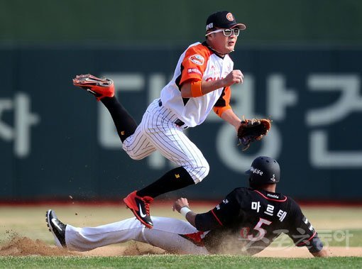 롯데 유격수 문규현(위)이 29일 사직 kt전 6회초 김상현의 내야 땅볼 때 1루주자 앤디 마르테를 포스아웃시킨 뒤 1루로 볼을 뿌리며 공을 쫓고 있다. 사직|김종원 기자 won@donga.com
