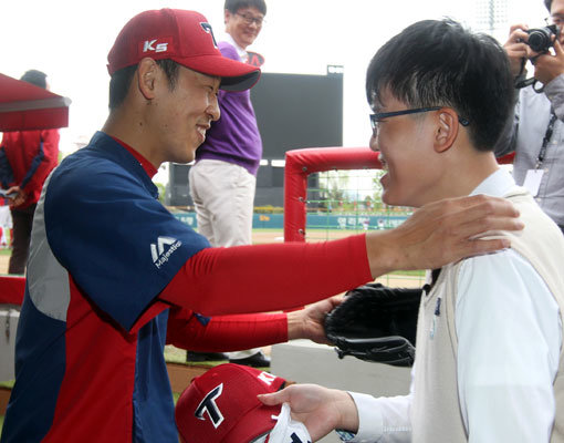 왼팔을 쓰지 못하는 야구선수 김성민(오른쪽) 군이 28일 시구를 할 예정이었던 광주 한화-KIA전이 우천취소된 뒤 자신의 우상인 KIA 투수 윤석민을 만나 반갑게 인사하고 있다. 사진제공｜스포츠코리아