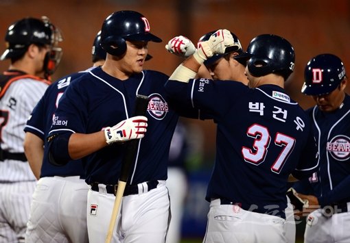 초전박살이다. 두산 오재일(왼쪽)이 22일 사직 롯데전 1회 2사 만루서 기선을 확실하게 제압하는 선제 결승 그랜드슬램을 쏘아 올린 뒤 홈에서 박건우를 비롯한 동료들과 기쁨을 나누고 있다. 사직|김민성 기자 marineboy@donga.com