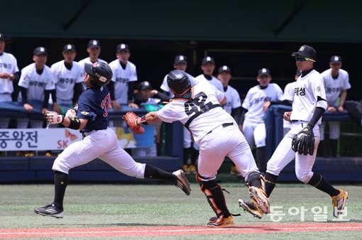 마산고 하선우(맨 왼쪽)가 8일 목동구장에서 열린 제70회 황금사자기 전국고교야구대회 동성고와 32강전에서 홈에서 태그를 피하기 위해 안간힘을 쓰고 있다. 목동｜홍진환 동아일보 기자 jean@donga.com