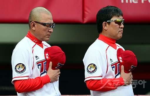 KIA 김기태 감독이 30일 광주-기아챔피언스필드에서 열린 SK와의 홈경기에 앞서 국민의례를 하면서 파르라니 깎은 머리를 드러냈다. 임창용이 위협견제구로 KBO로부터 3경기 출장정지 징계를 받은 데 대해 소속선수의 과오에 대한 책임을 통감하고 중요한 승부처에서 선수단의 마음을 다잡기 위한 삭발로 해석되고 있다. 광주 | 김민성 기자 marineboy@donga.com