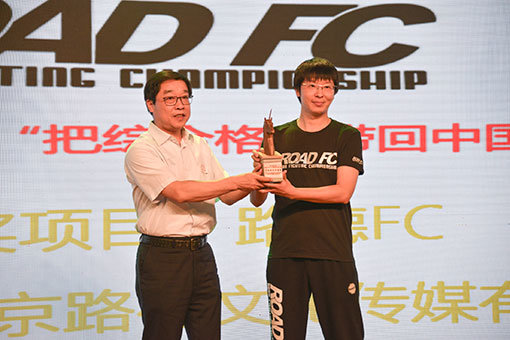베이징시 문화투자그룹 자오레이 총경리(사진 왼쪽)가 ROAD FC 현지법인 베이징로드 문화미디어유한공사 장쇼데이 사장에게 ‘화승은행 올해의 투자가치상’ 트로피를 전달하고 있다. 사진제공 ｜ ROAD FC
