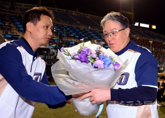 NC 김경문 감독(오른쪽)이 5일 마산 넥센전에서 승리하며 개인 통산 800승을 달성했다. NC 배석현 단장이 김 감독에게 꽃다발을 건네며 축하하고 있다. 창원｜김민성 기자 marineboy@donga.com