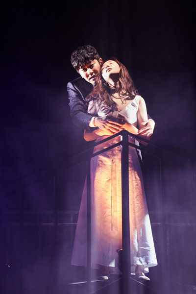 기괴한 걸작 뮤지컬 ‘더 데빌’에서 악마와 계약해 성공을 쟁취한 존 파우스트 역을 맡은 송용진이 사랑하는 연인 그레첸(이하나 분)을 끌어안고 노래하는 장면. 사진제공 ㅣ 페이지원·알앤디웍스